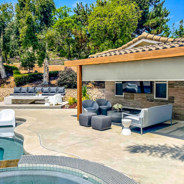 large outdoor entertainment area with motorized shades installed by Ventana Outdoor Shades & Awnings in Houston, TX