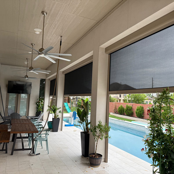 dining area under a covered patio with motorized shades installed by Ventana Outdoor Shades & Awnings in Houston, TX